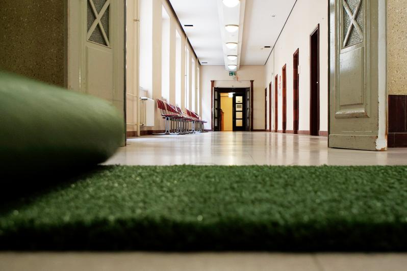 Grüner Teppich rollt entlang eines Flurs der Verwaltung.